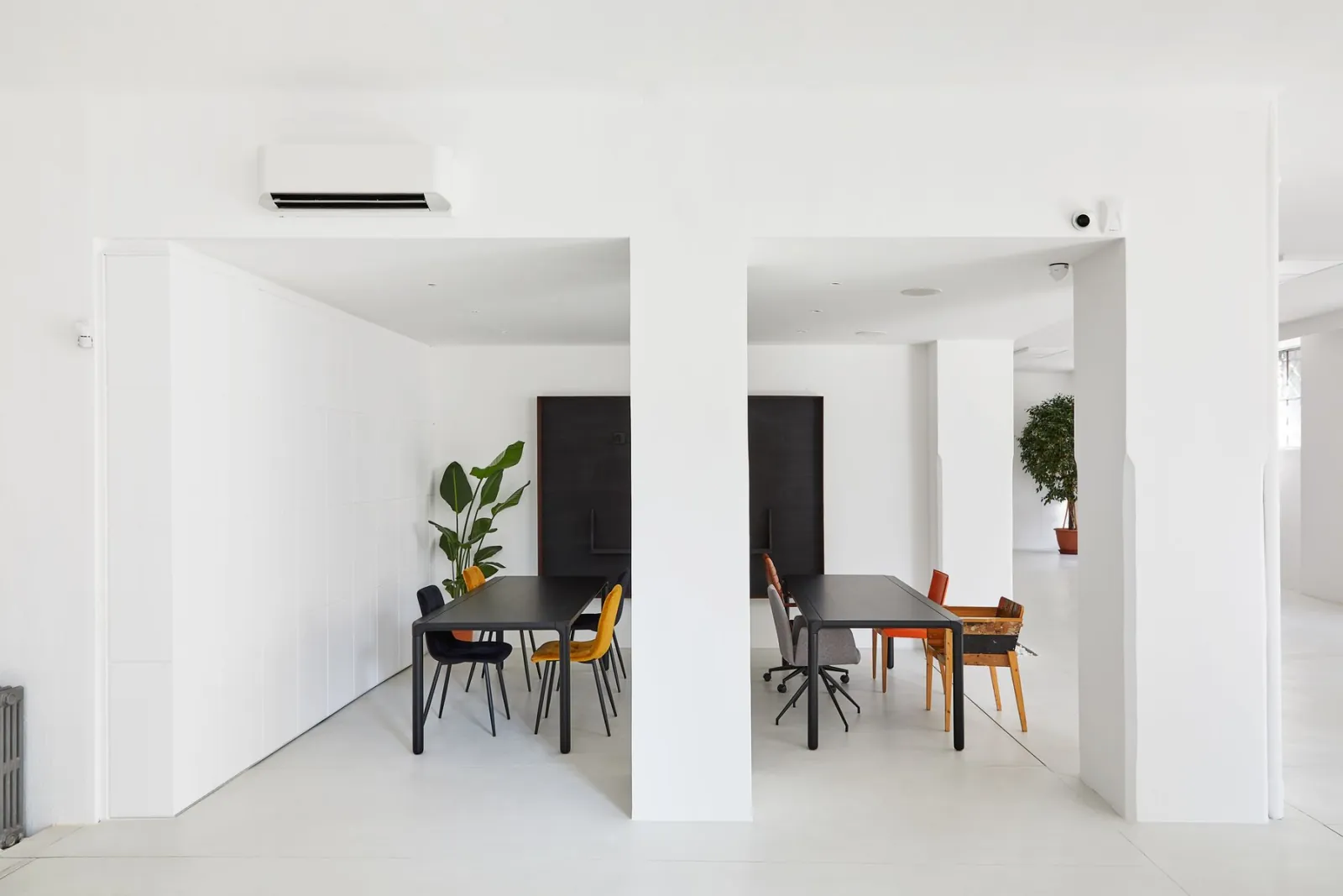 A bright white meeting room with a plain table.